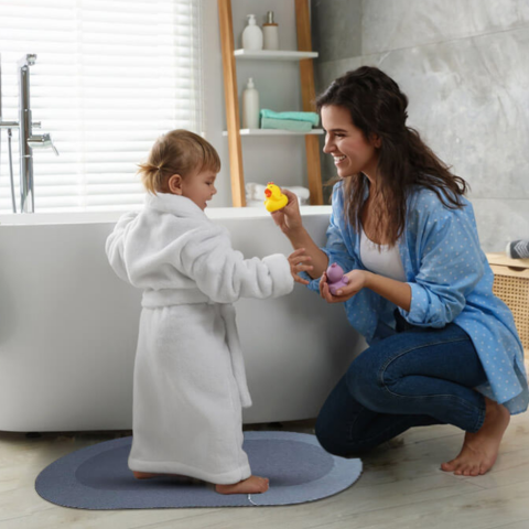 mother playing with daughter in bathroom with Maas & Bath SecureMat